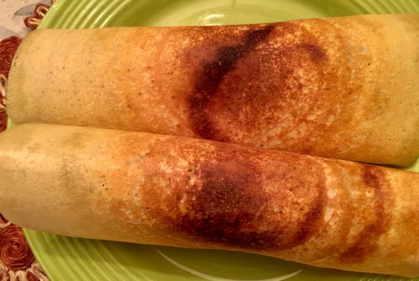 two masala dosas on a plate
