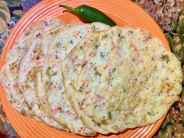 onion uthappam with onions, green chili, bell peppers, tomato and cliantro